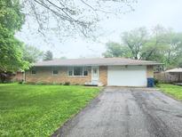 Charming brick ranch home with a long driveway and an attached two car garage at 7109 Chandler Dr, Indianapolis, IN 46217