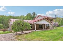 Charming home featuring a red roof, stone accents, covered porch and a lush green lawn at 775 Baker Rd, Martinsville, IN 46151