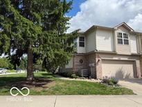 Charming two-story home featuring a well-manicured lawn, attached garage, and beautiful landscaping at 8002 Windham Lake Way # 33, Indianapolis, IN 46214