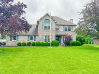 Charming two-story home with brick exterior, green shutters, and well-manicured lawn and landscaping at 8798 Surrey Dr, Pendleton, IN 46064