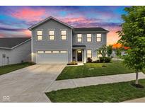 Beautiful two-story home featuring a well-manicured lawn and attached two-car garage, illuminated by a vibrant sunset at 900 Sunchaser Rd, Lebanon, IN 46052