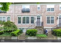 Charming townhouse with inviting stone steps, manicured bushes, and a neutral stucco facade at 952 Junction Pl, Indianapolis, IN 46220