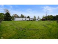 Expansive backyard featuring a well-maintained lawn and a white single-story home at 9621 N County Road 25 W, Muncie, IN 47303