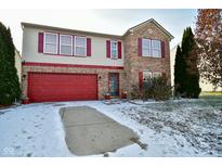 Charming two-story home featuring a red garage door, red shutters, brick accents, and a well-maintained front yard at 9955 Orange Blossom Trl, Fishers, IN 46038