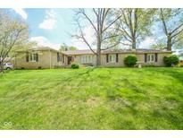 Charming single-story stone home with a well-manicured lawn and mature trees at 10827 Wonderland Dr, Indianapolis, IN 46239