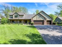 Charming home features an attached three car garage and a well manicured front lawn at 11471 Clarkston Rd, Zionsville, IN 46077