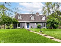 Charming gray home with a lush front lawn, beautiful landscaping and inviting blue front door at 11550 Clarkston Rd, Zionsville, IN 46077