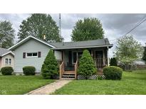 Charming single-story home with a cozy front porch, well-maintained lawn, and mature landscaping at 1202 S Ribble Ave, Muncie, IN 47302
