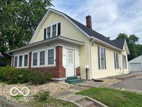 Charming two-story home with a brick foundation, yellow siding, and a well-maintained front yard at 1440 E Morgan E St, Martinsville, IN 46151
