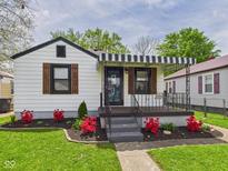 Charming home with a striped awning, landscaped flower beds, and a well-maintained lawn at 1505 E 30Th St, Anderson, IN 46016