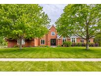 Charming two-story brick home with mature trees and a well-manicured lawn at 1510 Continental Dr, Zionsville, IN 46077