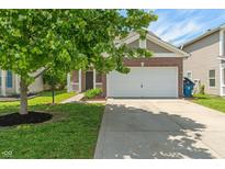 Charming home featuring a two-car garage, brick accents, and a beautifully landscaped front yard with a mature tree at 4136 Orchard Valley Ln, Indianapolis, IN 46235