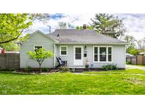 Charming single story home with a manicured lawn, flowering tree, and welcoming front porch at 5643 Rosslyn Ave, Indianapolis, IN 46220