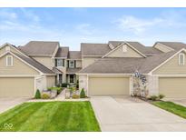 Charming townhome with an attached two-car garage, well-maintained lawn, and welcoming front entrance at 5744 Spruce Knoll Ct, Indianapolis, IN 46220