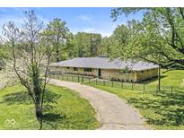 Charming single-story home with a long driveway and fenced front yard, perfect for a Gathering at 6464 Whitley Ln, Indianapolis, IN 46260