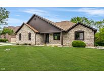 Charming single-story brick home with a well-manicured lawn and inviting front porch at 7665 Stones River Ct, Indianapolis, IN 46259