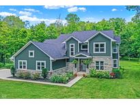 Beautiful two-story home with stone accents and landscaped front yard on a sunny day at 7716 Traders Hollow Ln, Indianapolis, IN 46278
