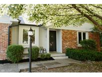 Home exterior boasts a cozy front porch with brick detail, decorative lamp, and manicured landscaping at 780 Wilson Terrace Ct, Carmel, IN 46032