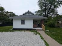 Charming single-story home featuring a gravel front yard and a cozy, covered entrance with brick columns at 1009 Chestnut St, Anderson, IN 46012