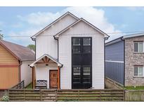 Modern two-story home with white siding, a dark window accent, and a rustic wood fence at 1009 Harrison St, Indianapolis, IN 46202