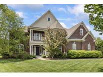 Charming two-story brick home featuring a welcoming front porch and beautifully manicured lawn at 10504 Ruxton Ct, Fishers, IN 46040