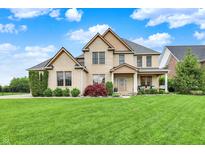 Beautiful two story brick home with a manicured lawn, landscaping and a welcoming front porch at 12152 Teal Ln, Carmel, IN 46032