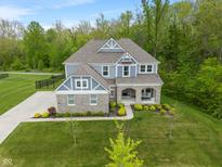Stunning aerial view of a two-story home with stone accents and a spacious landscaped yard at 12811 Corydon Dr, Fishers, IN 46037