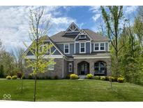 Beautiful two-story home with stone accents, covered porch, and well-manicured lawn at 12811 Corydon Dr, Fishers, IN 46037