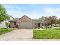 Charming single-story home with brick accents, a well-manicured lawn, and an attached two-car garage at 1283 Easton Point Dr, Greenwood, IN 46142