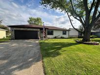 Charming single-story home with a stone and siding exterior, an attached garage, and a well-manicured lawn at 1513 Ashley Dr, Lebanon, IN 46052