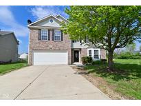 Charming two-story home featuring a brick facade, attached two-car garage, and lush front yard landscaping at 1966 Freedom Ct, Greenfield, IN 46140