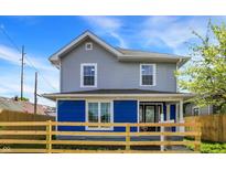 Charming two-story home with a blue-and-gray exterior, complemented by a well-maintained yard and wood fence at 213 S State Ave, Indianapolis, IN 46201