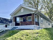 Charming bungalow with brick accents and a welcoming front porch on a well-manicured lawn at 2141 Napoleon St, Indianapolis, IN 46203