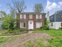 Two-story brick home featuring symmetrical design, white-trimmed windows, and a classic front door at 3516 Janet Dr, Indianapolis, IN 46218