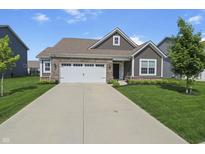Charming single-story home with a well-manicured lawn, brick accents, and a two-car garage at 4324 Homestead Dr, Whitestown, IN 46075