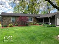 Charming stone home featuring lush landscaping and a well-maintained green lawn at 569 Meadow Dr, Danville, IN 46122