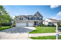Beautiful two-story home featuring a manicured lawn, brick accents, and a three-car garage at 6064 Bartley Dr, Noblesville, IN 46062