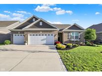 Single Gathering home featuring a well-manicured lawn, three car garage, and brick details at 6153 Dugan Dr, Whitestown, IN 46075