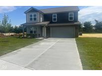 New two-story home with a concrete driveway and two car attached garage and newly landscaped lawn at 7509 Big Bend Blvd, Camby, IN 46113