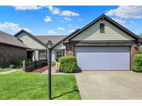 Charming home featuring a two-car garage, well-kept lawn, and lovely landscaping, perfect for suburban living at 7702 Justin Ln, Indianapolis, IN 46219