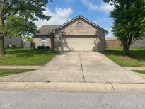 Charming brick home with an attached two car garage and a long driveway at 8054 Painted Pony Dr, Indianapolis, IN 46217