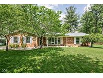 Charming brick ranch-style home featuring a well-manicured lawn and mature trees at 818 Merry Ln, Greenwood, IN 46142