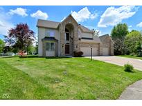 Inviting two-story home with a three car garage and landscaped front yard at 8627 Lansdowne Dr, Fishers, IN 46038