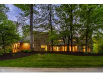 Stunning stone home with lush landscaping and mature trees providing privacy and curb appeal at 9387 Sullivan Pl, Zionsville, IN 46077