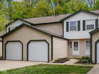 Charming townhome features a two-car garage, neutral siding, green trim, and a well-manicured lawn at 9493 Timber View Dr, Indianapolis, IN 46250
