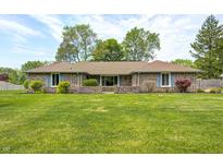 Charming brick home featuring a lush green lawn, mature trees, and lovely landscaping at 101 N Westbury Rd, Pendleton, IN 46064