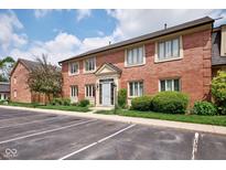 Exterior view of a charming two-story red brick building with beautiful landscaping and a parking lot at 1142 Canterbury S Sq # B, Indianapolis, IN 46260