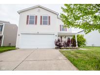 Two-story home features a two-car garage, a front lawn, and landscaping at 1404 Norton Dr, Greenwood, IN 46143