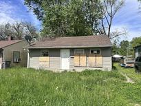 Modest single-story home featuring a brown roof, boarded up windows and a simple front door at 3114 Adams St, Indianapolis, IN 46218