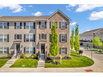Attractive brick townhome with black shutters, tidy landscaping and inviting curb appeal under a bright blue sky at 3546 Brampton Ln, Westfield, IN 46074